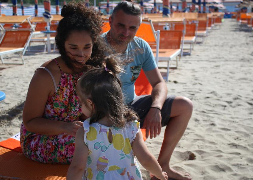 Smiling family on the beach, sun and summer joy.